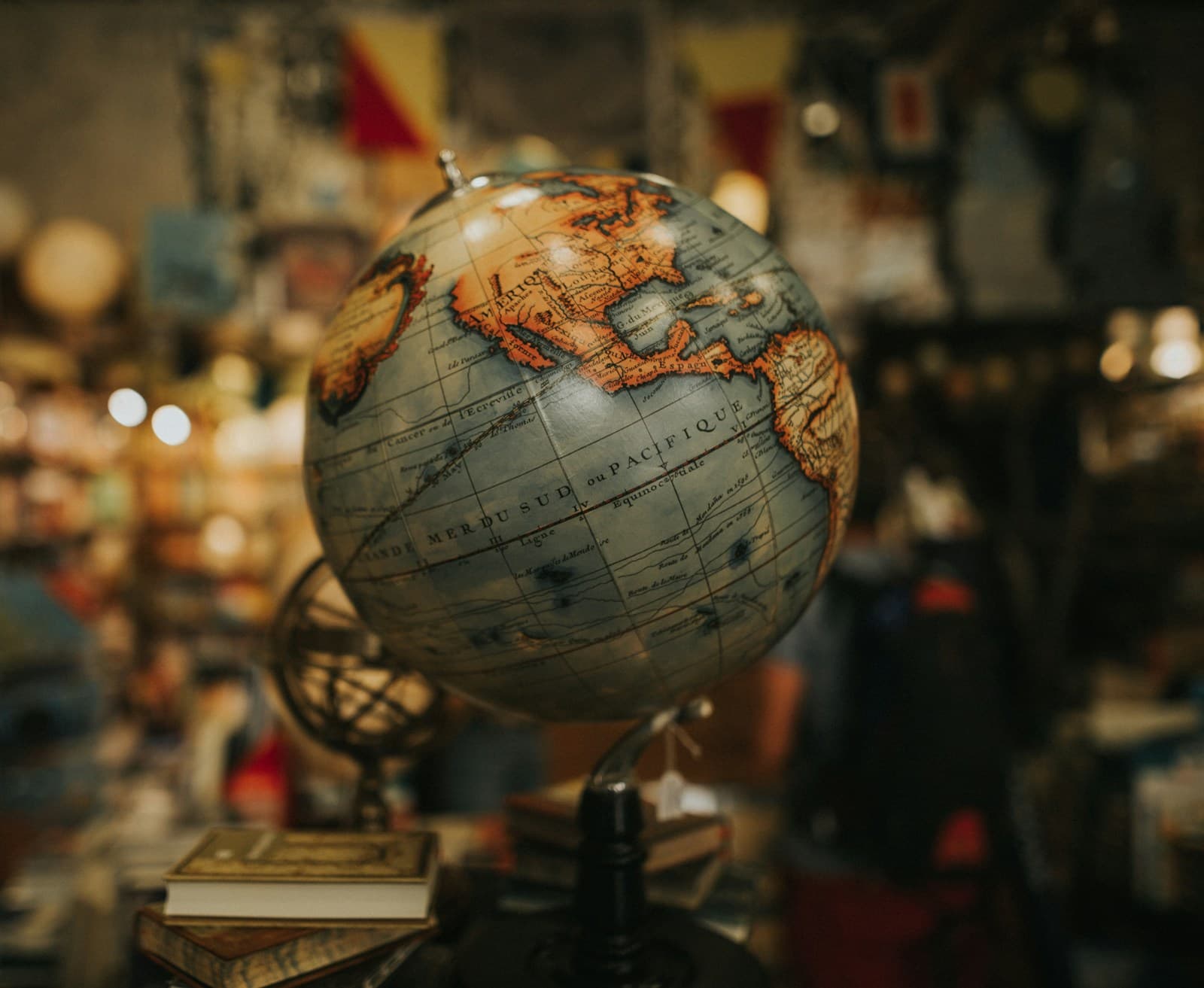 Decorative globe beside stacked books in a library setting.