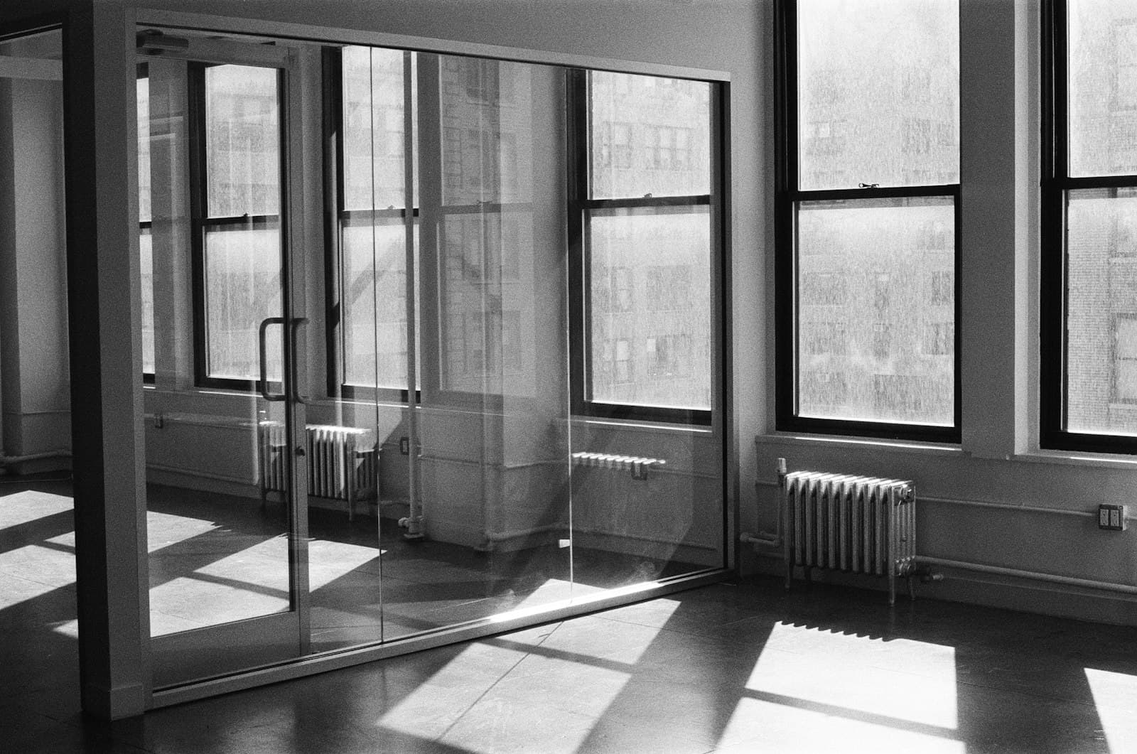 Sunlight entering an empty office through tall windows