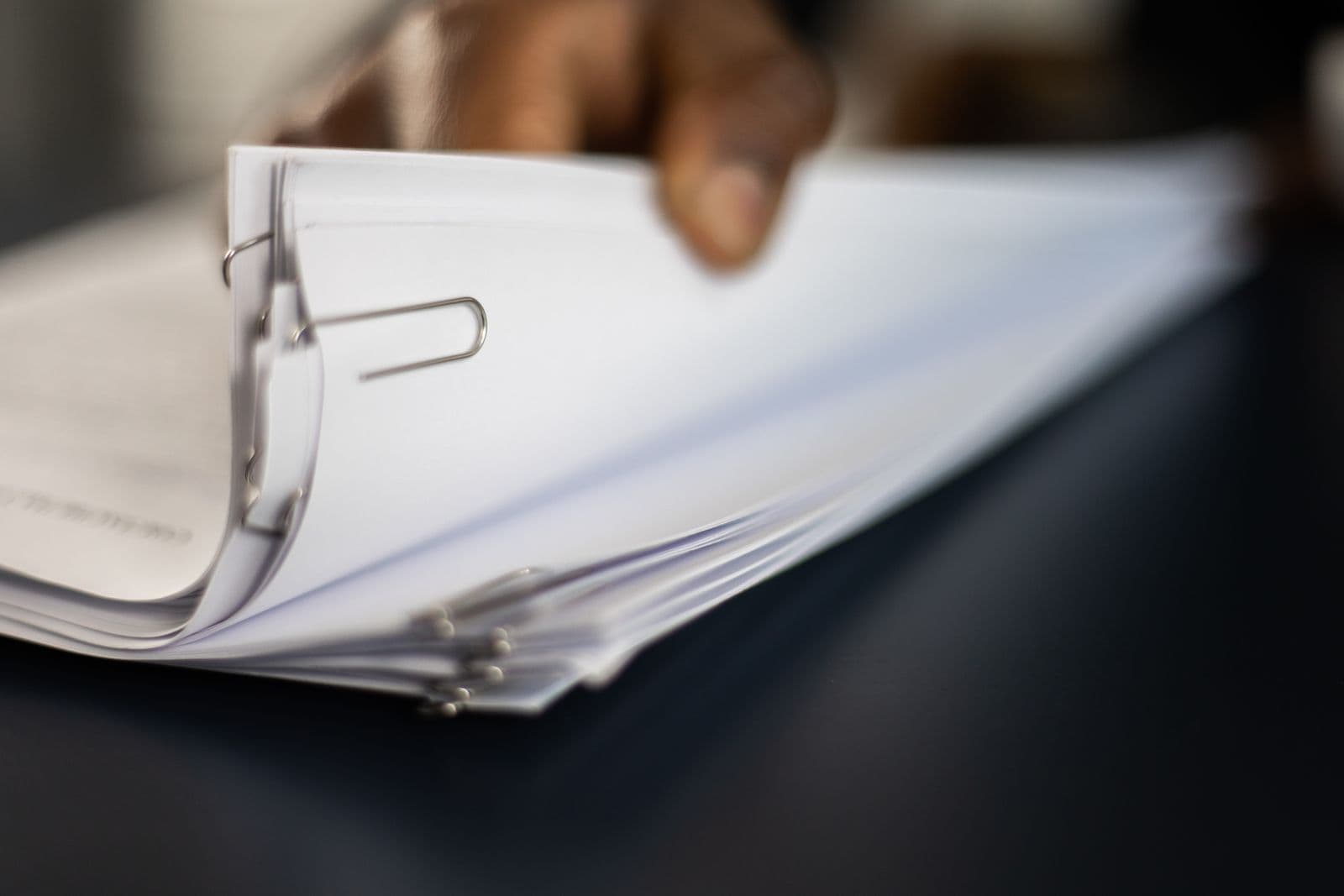Close-up of clipped document bundles being reviewed.