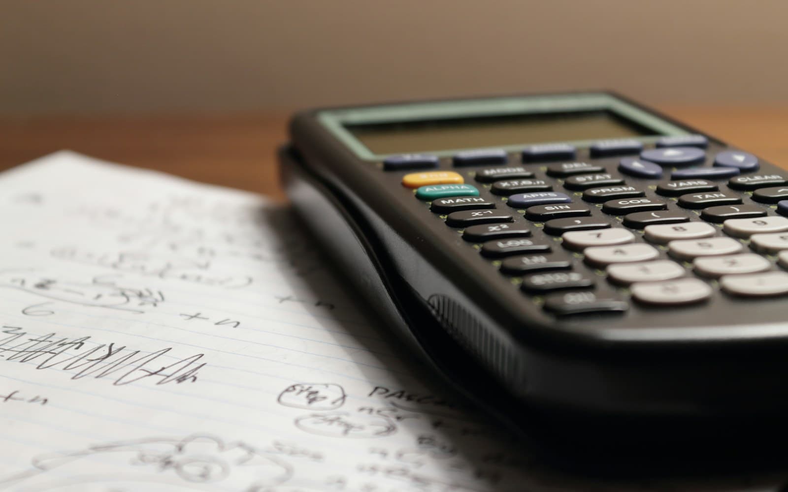 Close-up of a calculator on handwritten working papers.