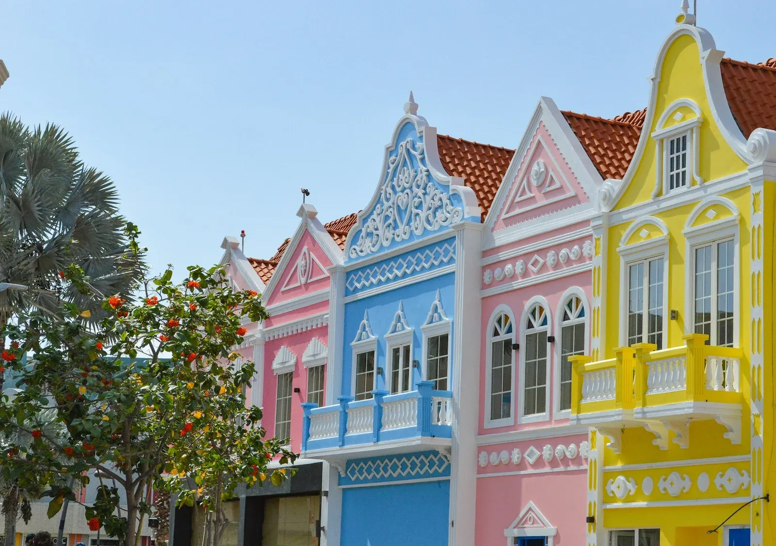 Pastel-coloured building facades and palm trees in Oranjestad, Aruba.