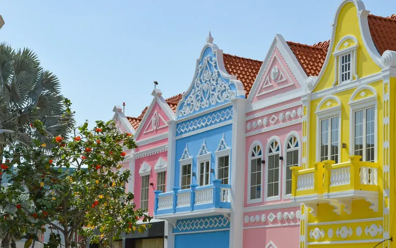 Pastel-coloured building facades and palm trees in Oranjestad, Aruba.