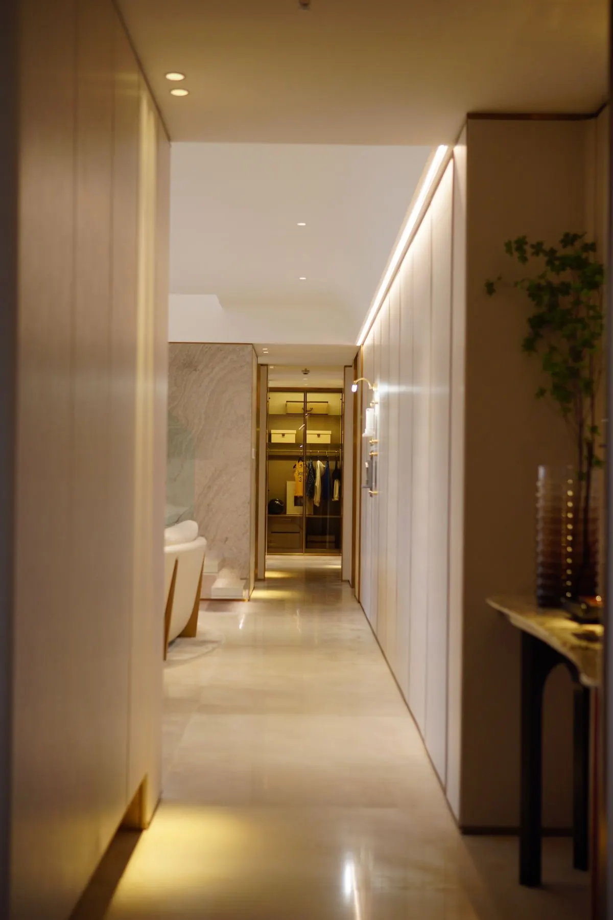 An empty hotel interior corridor with warm lighting and a polished floor.