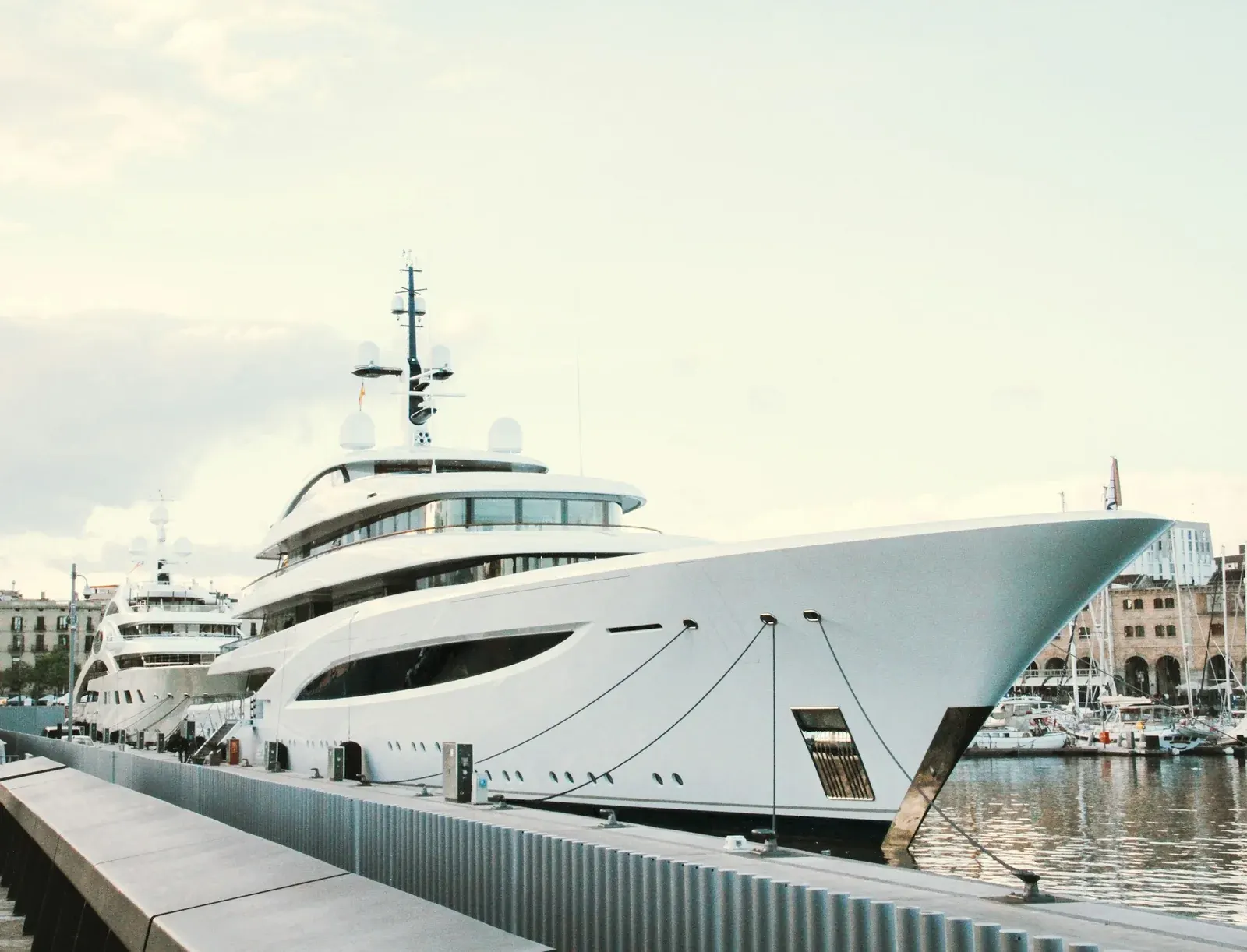 White motor yacht moored beside a marina quay in Barcelona.