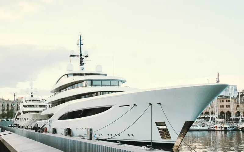 White motor yacht moored beside a marina quay in Barcelona.