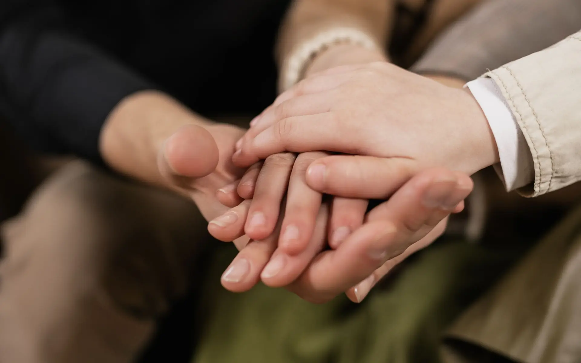 Family members resting their hands together.