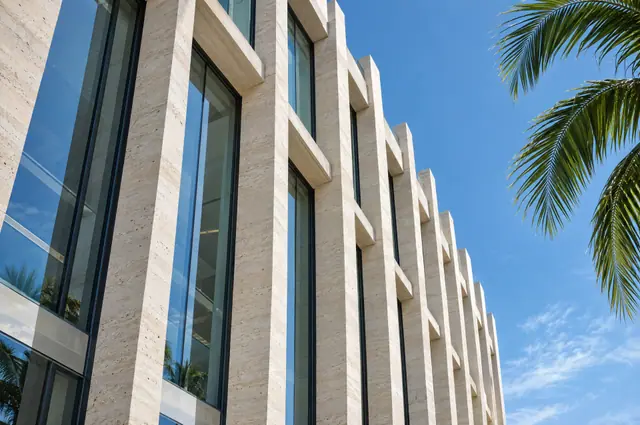 Travertine and glass office facade against a blue sky